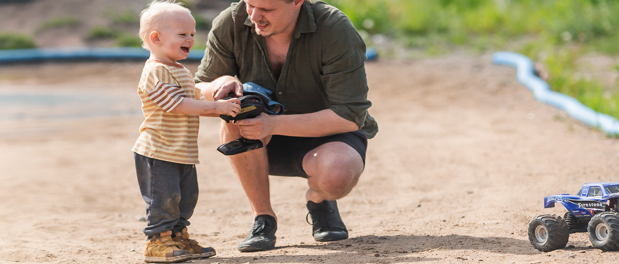 Barn och vuxen kör radiostyrd bil tillsammans